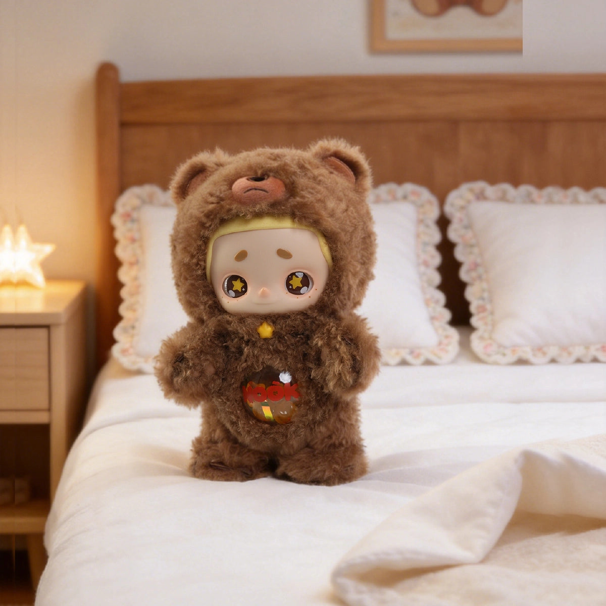 NOOK Star Keeper Bear vinyl plush standing on a bed beside a glowing star light