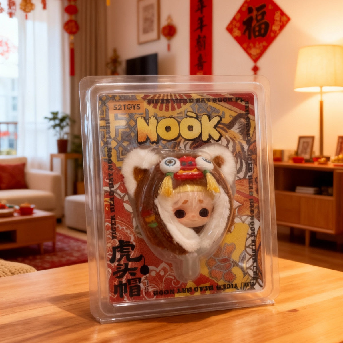 NOOK tiger-head hat plush charm in its clear clamshell package in a decorated living room