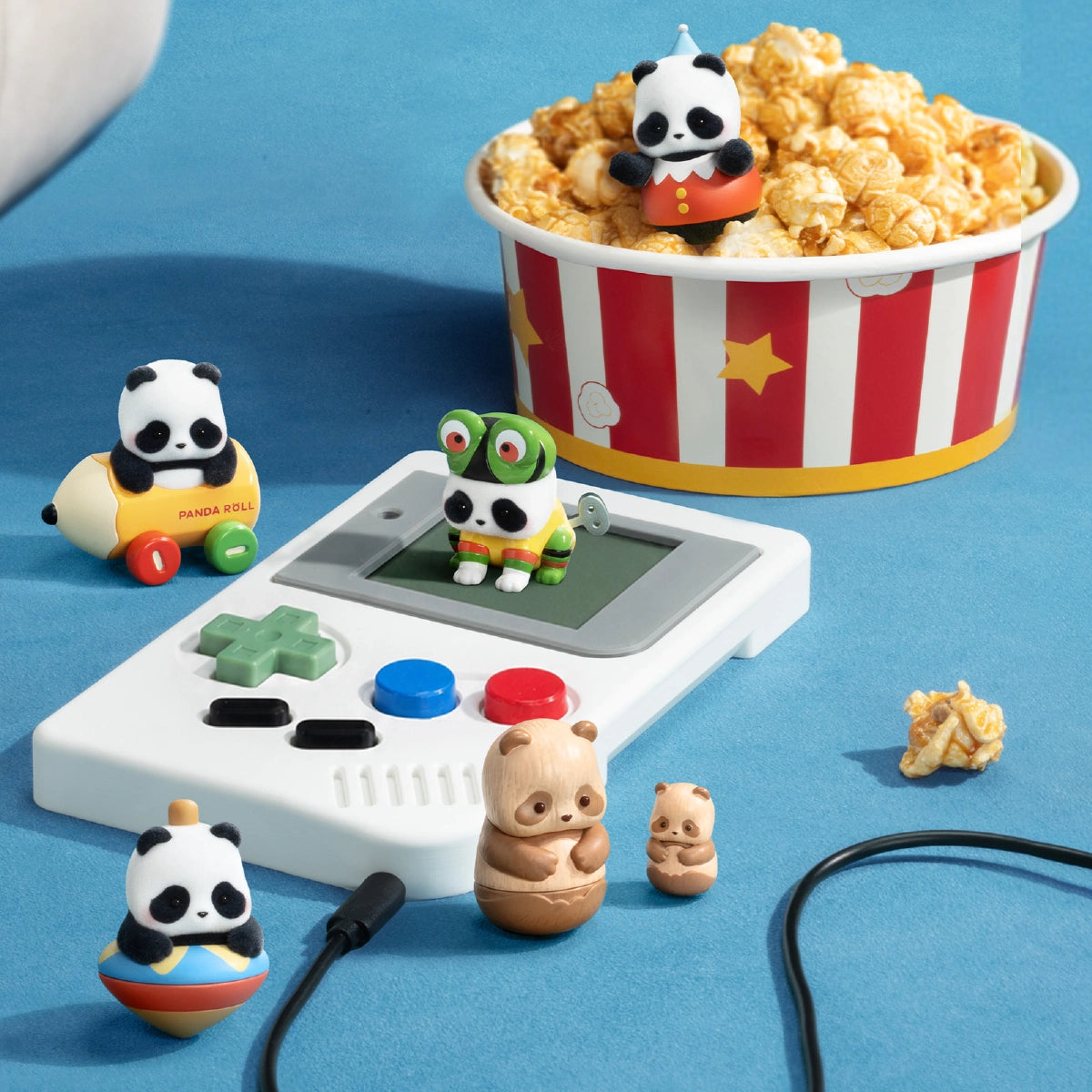 Panda Roll MiniMe figures arranged around a handheld game console and popcorn tub
