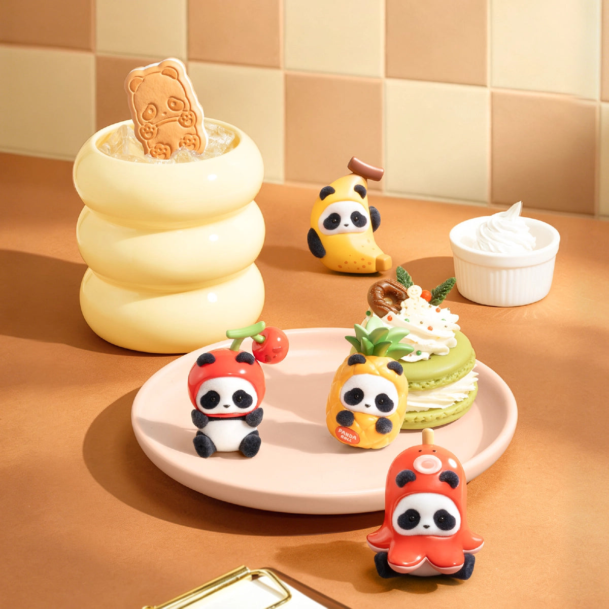 Panda Roll MiniMe figures gathered around desserts on a cream-colored plate