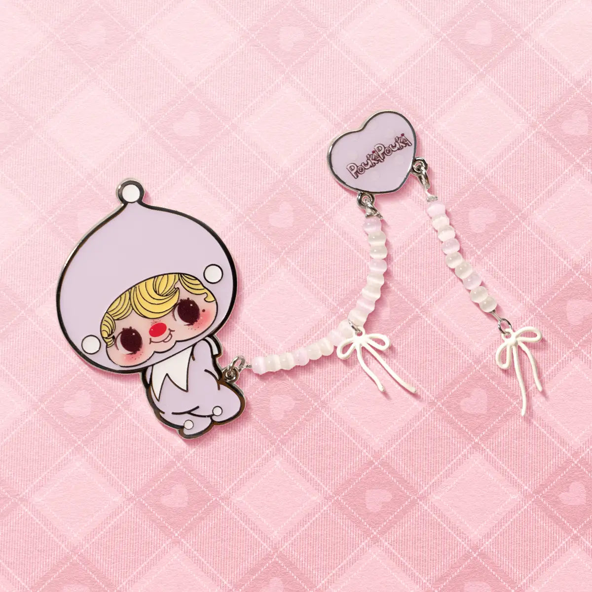 POUKA Sweet Lilac Brooch on pink heart backdrop, lilac enamel baby with white beaded bow strap, POUKAPOUKA