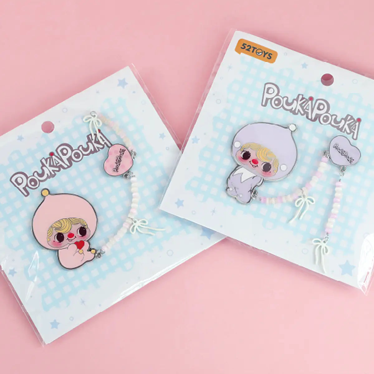 Lilac and pink POUKA brooches in sealed POUKAPOUKA blister packs with beaded bow straps