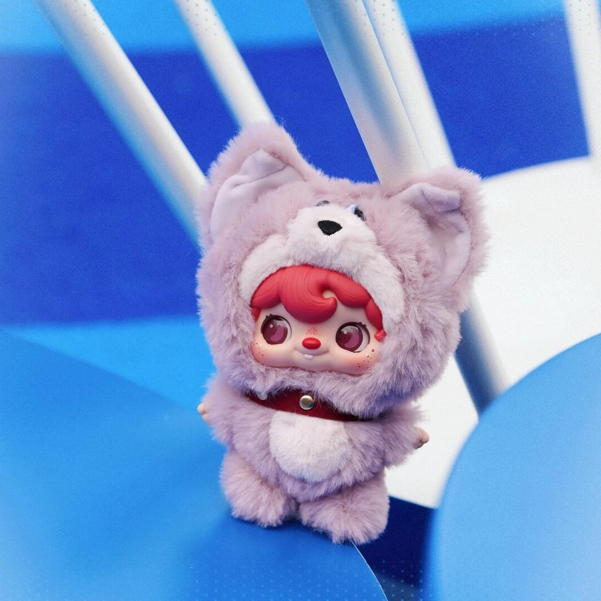 POUKAPOUKA in a lavender Tom costume posed on a blue chair