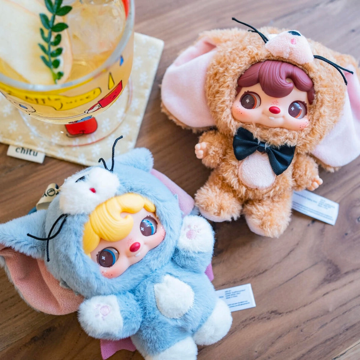 POUKAPOUKA gray Tom and brown Jerry costume plush toys lying beside a drink