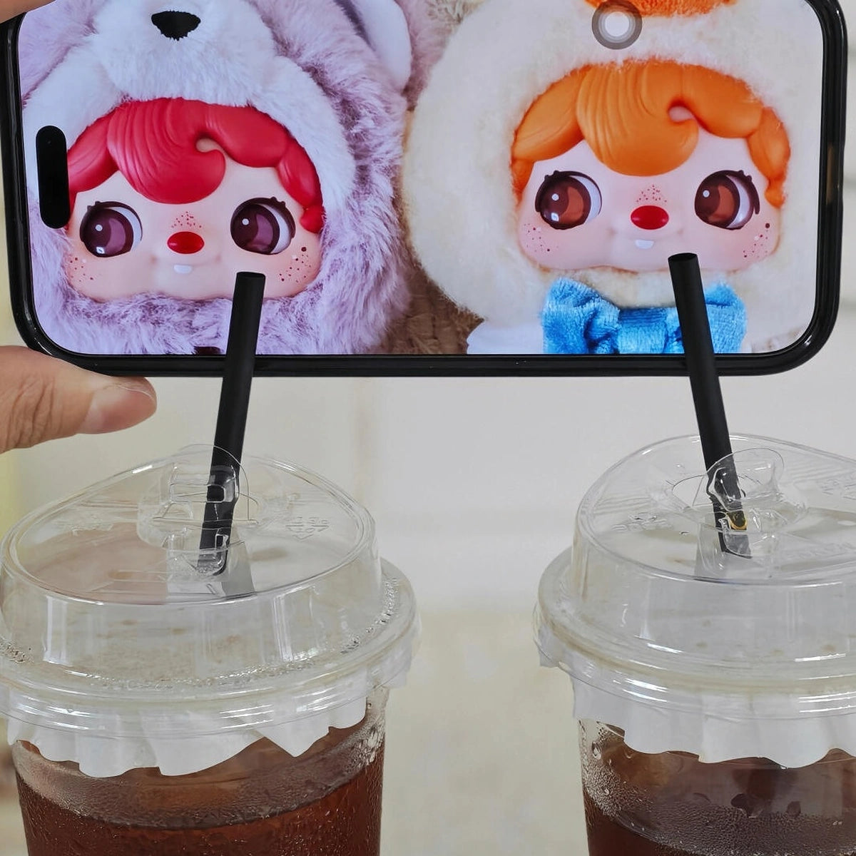 POUKAPOUKA Tom and Quacker character close-ups displayed above two drink cups