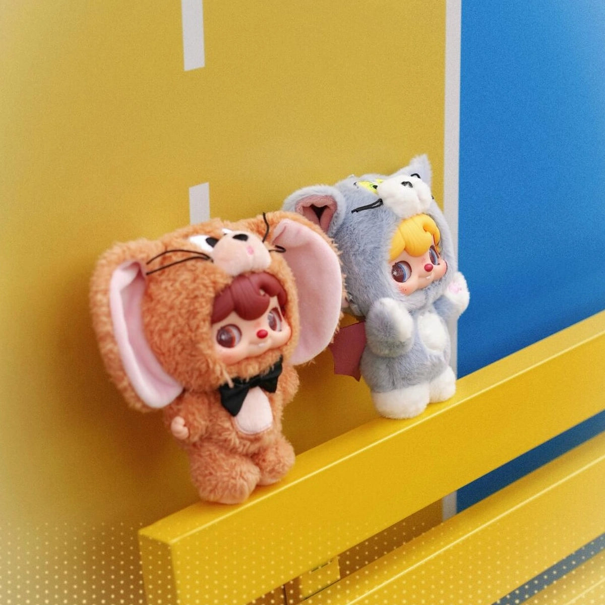 POUKAPOUKA brown Jerry and gray Tom costume plush toys on a yellow-and-blue display