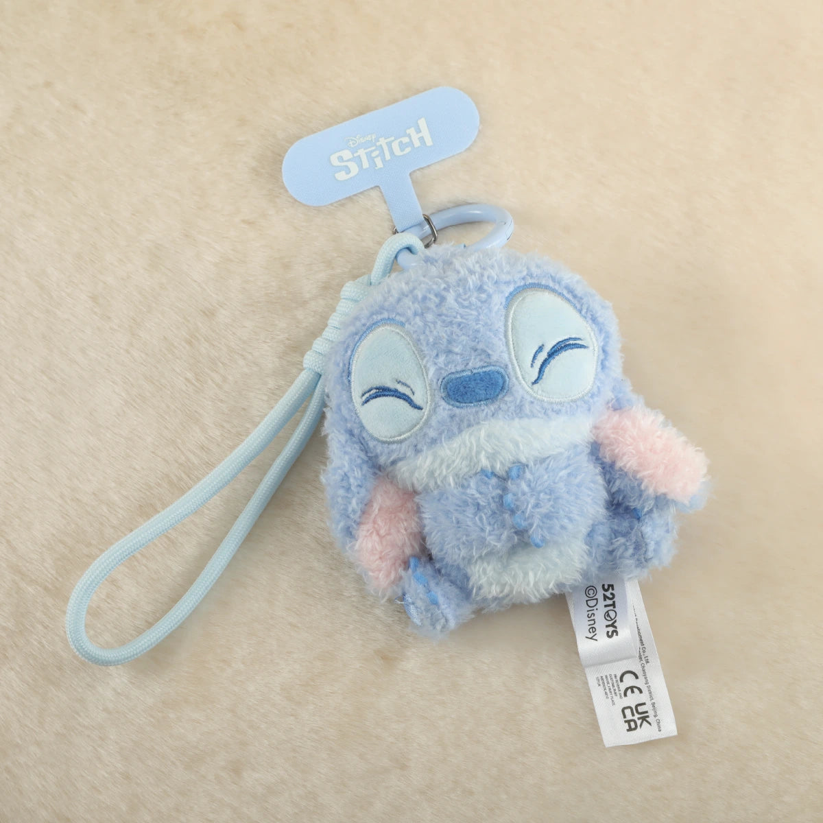 Smiling Stitch plush phone charm with closed eyes and a blue wrist strap