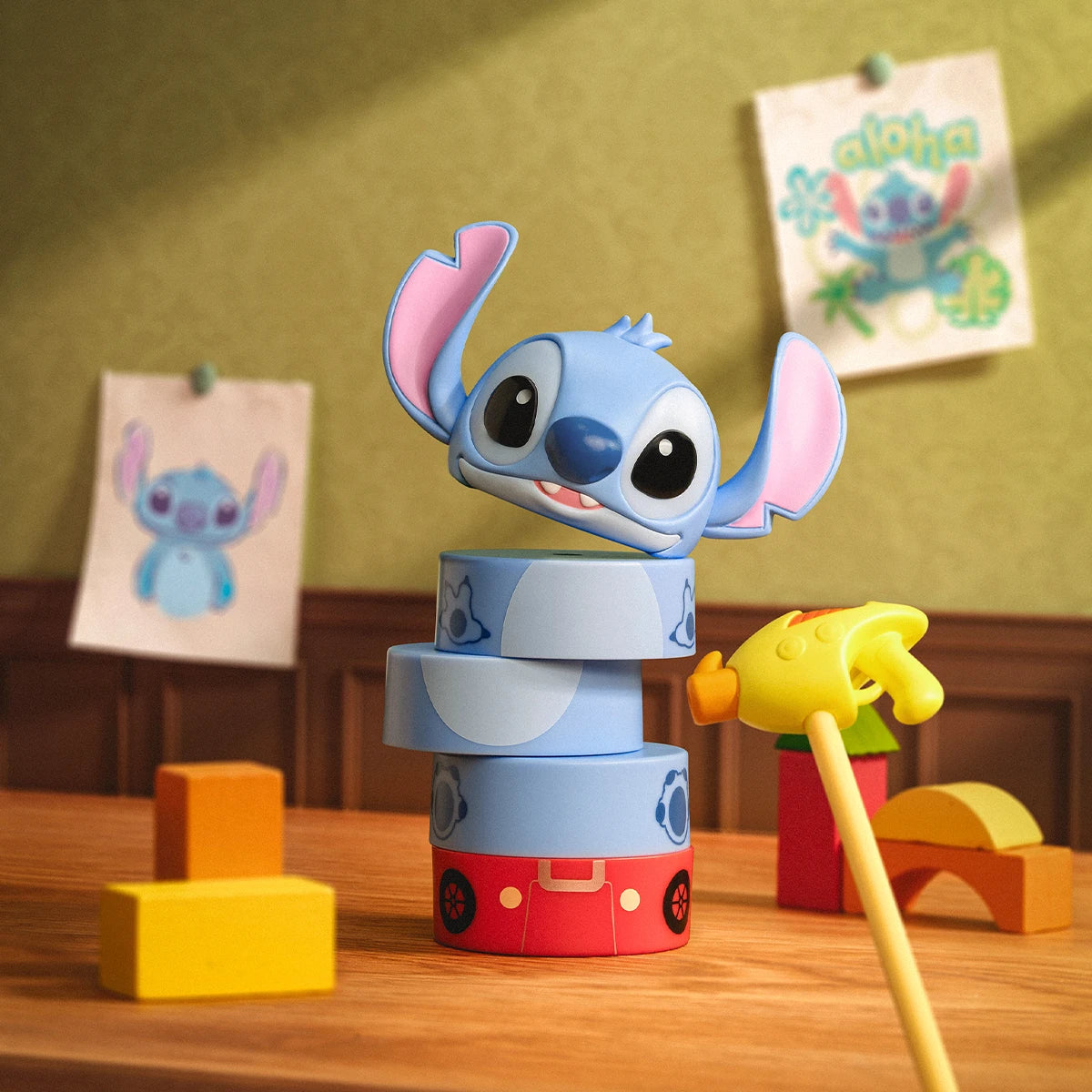 Stitch popping out of stacked vintage toy rings beside a yellow pull toy