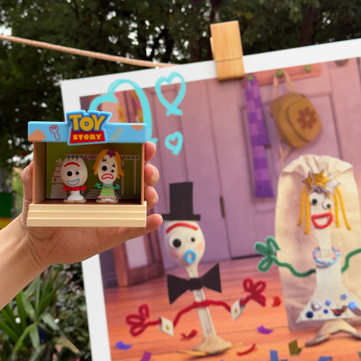 Forky and Karen Beverly stage figure held outdoors before its matching mural