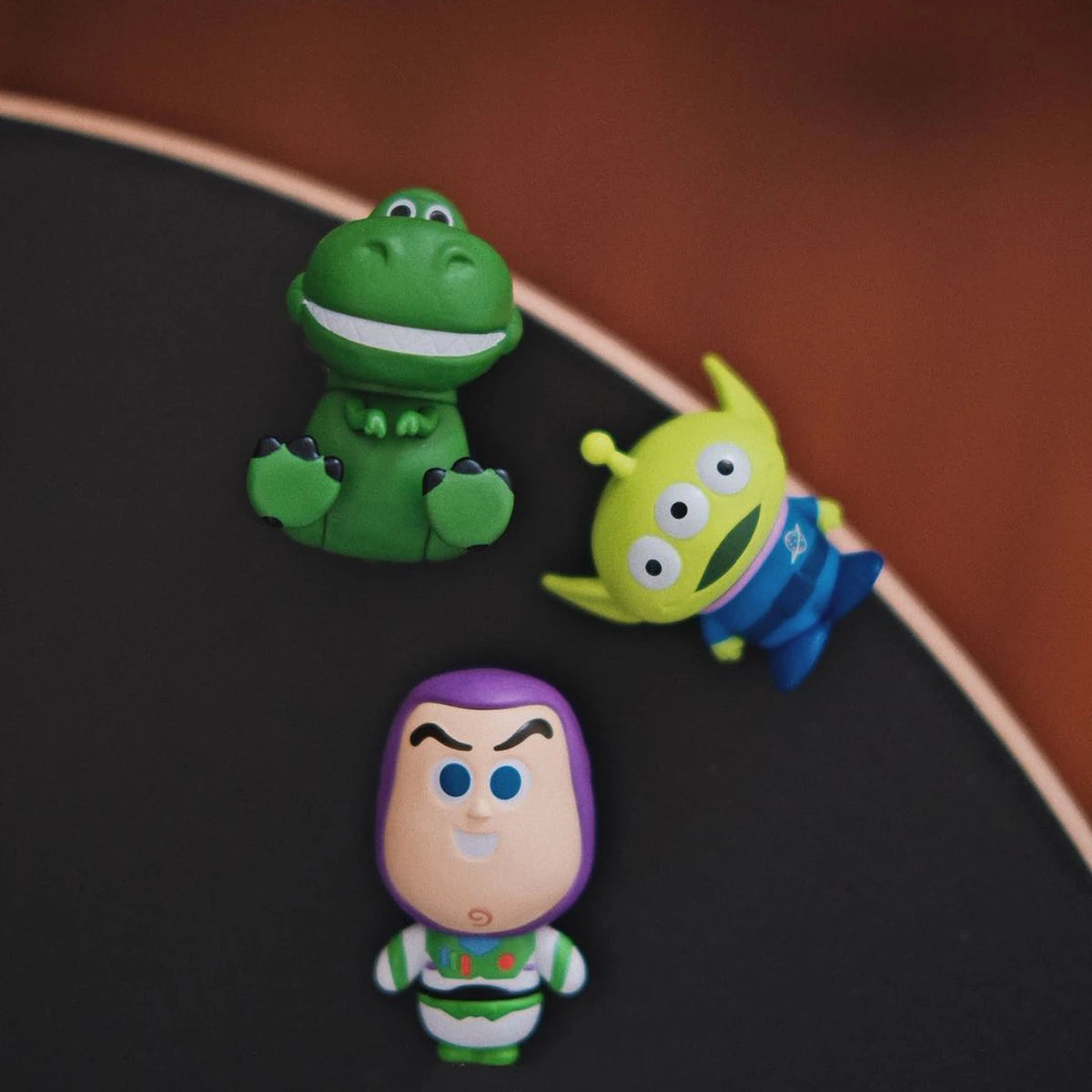 暗黒のテーブル上でレックス,トイ・ストーリー・エイリアン, and Buzz Lightyear MiniMe figures on a dark tabletop