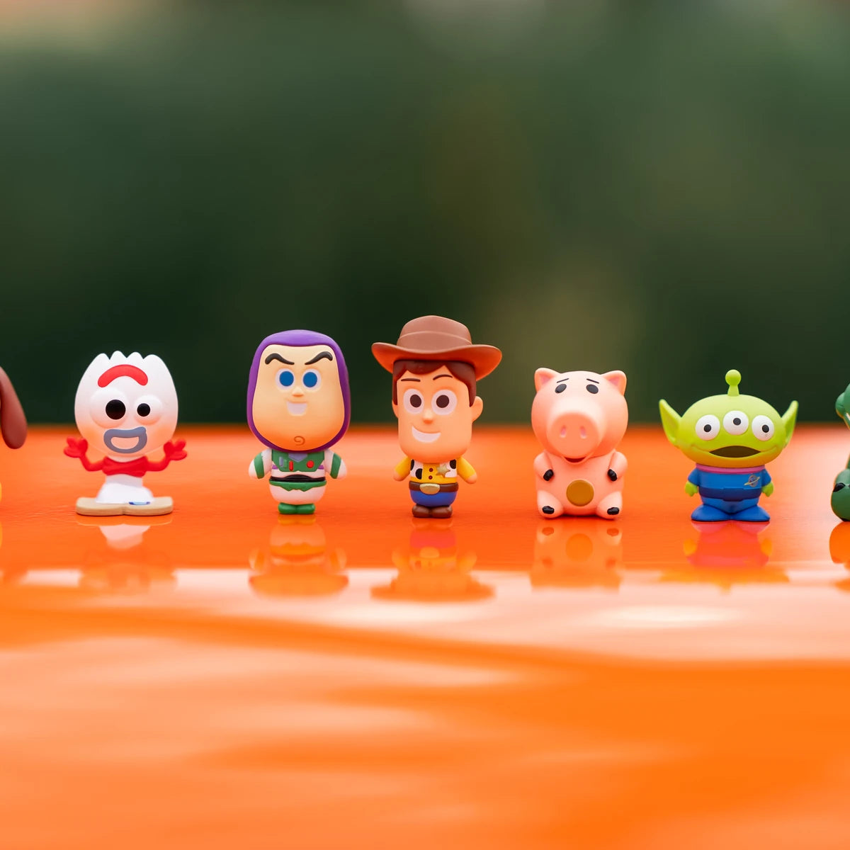 フォルキー,バズ,ウッディ,ハム,トイ・ストーリー エイリアン ミニミーフィギュアはオレンジ色の表面に並ぶ・Woody
