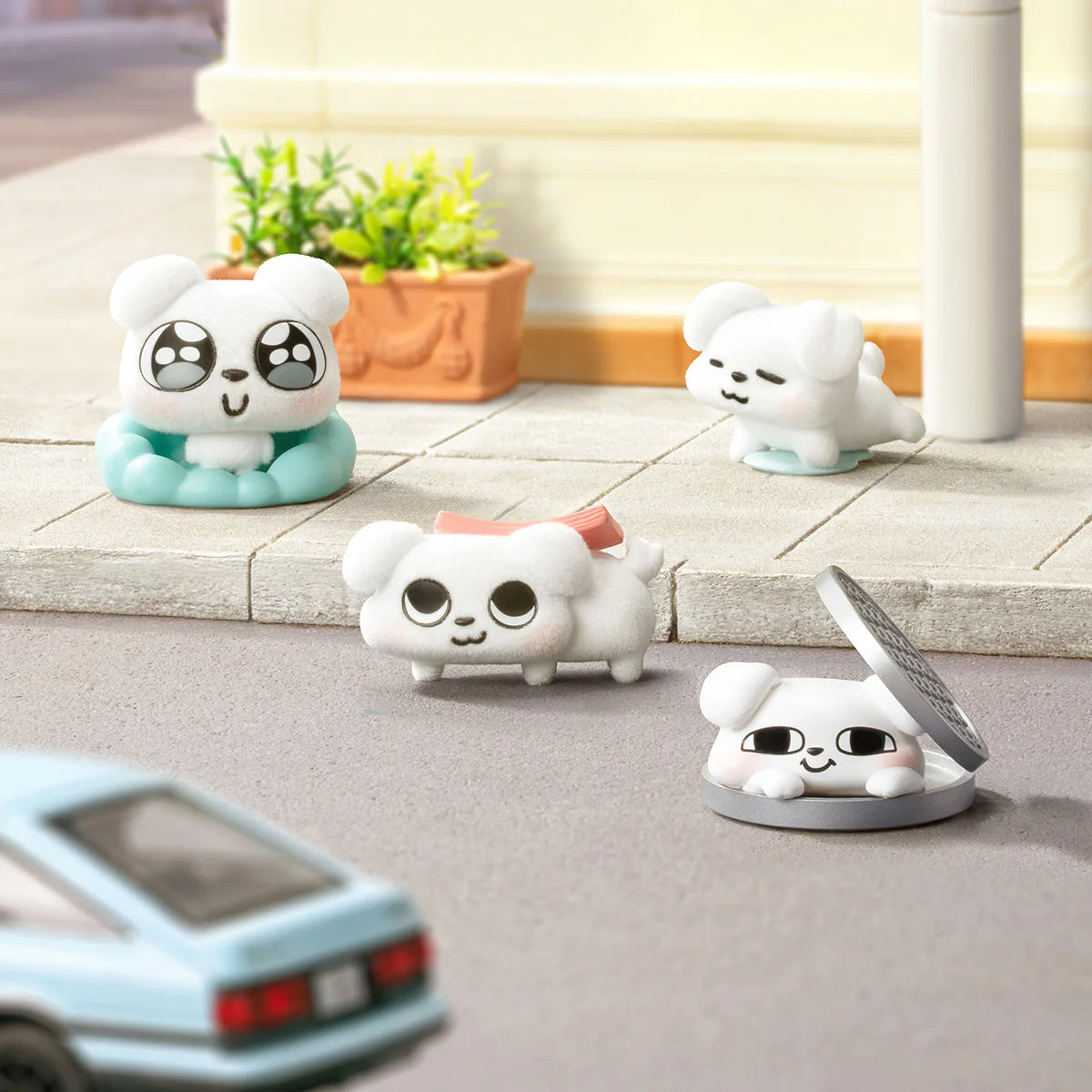 Zoggy dog figures on a curb including Peace Out sliding into a drain cover, So Cute